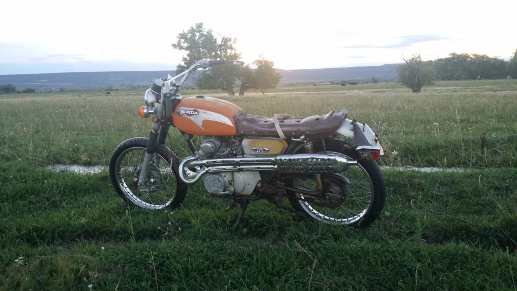 Weathered 1971 Honda CL175 barn find sitting in a farm pasture